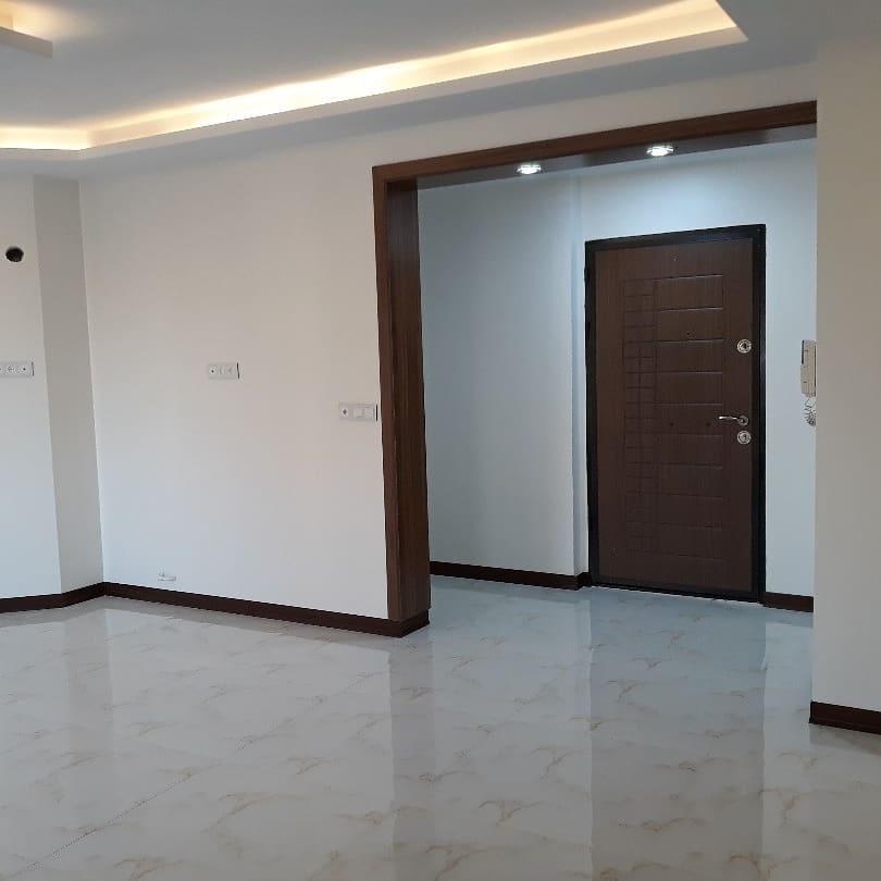 Yenileme tamamlandıktan sonra modern oturma odası, parlak seramikler ve giriş kapısının görünümü